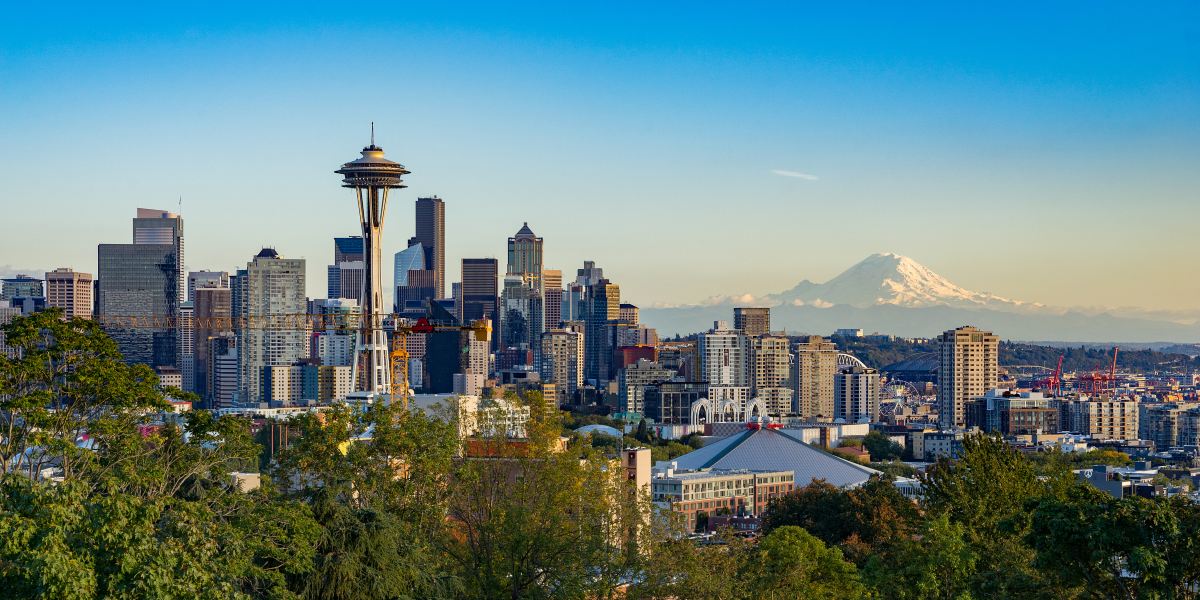 The Space Needle above the downtown Seattle skyline with Mount Rainier in the distance