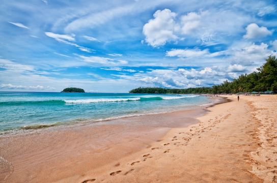 หาดทรายกว้างกับคลื่นเบาและแนวเขียวของหาดกะตะ
