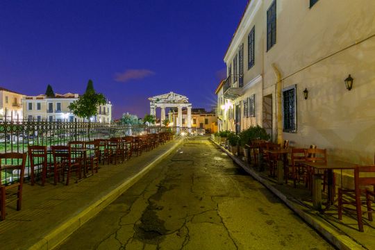 A street in Plaka at night, with the gate of the Roman agora at the end
