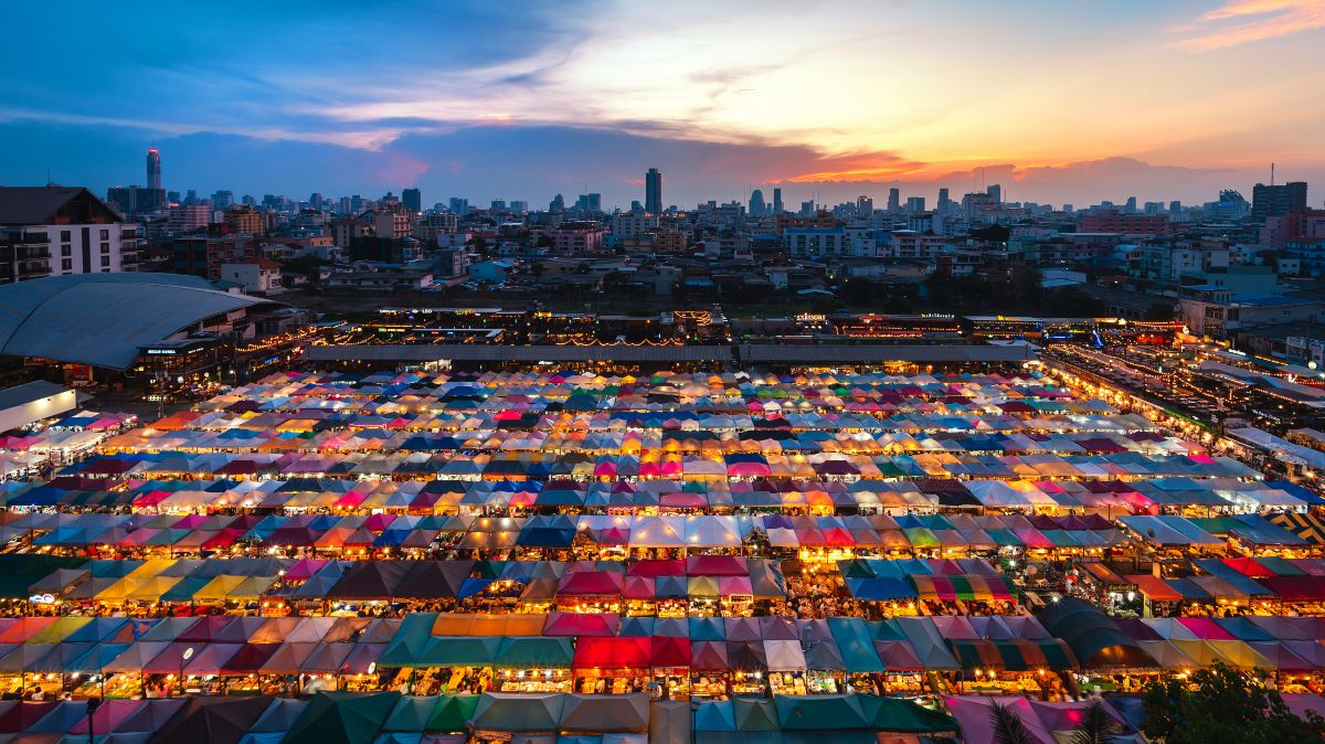 Rows of market tents lit at dusk in the Ratchadaphisek district of Bangkok