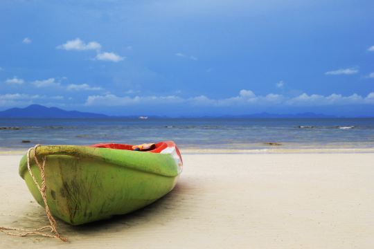 My Khe Beach with a green coracle boat, close to beachfront Da Nang hotels