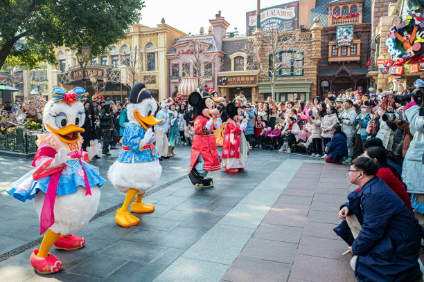 上海ディズニーランドで、中国風衣装を着たミッキーやドナルドが観客の前でパレードしている。