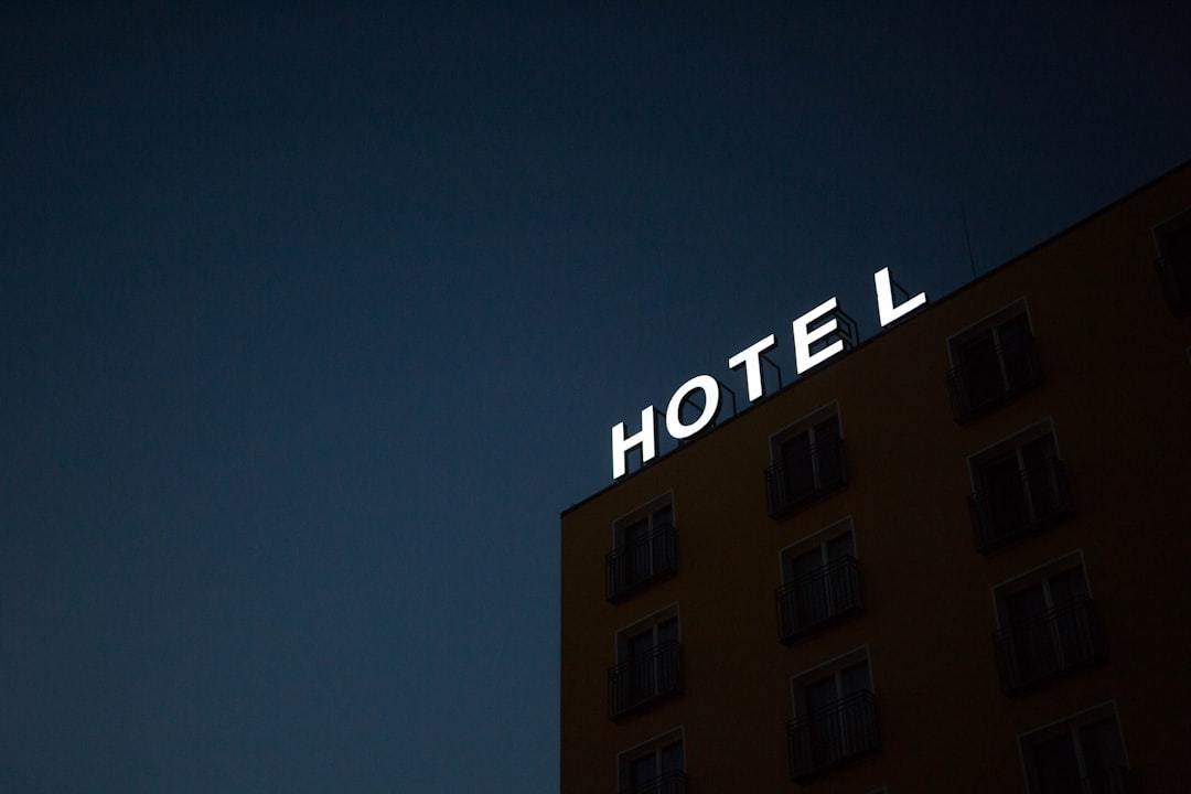 low-angle photo of Hotel lighted signage on top of brown building during nighttime Via Unsplash (by Marten Bjork)