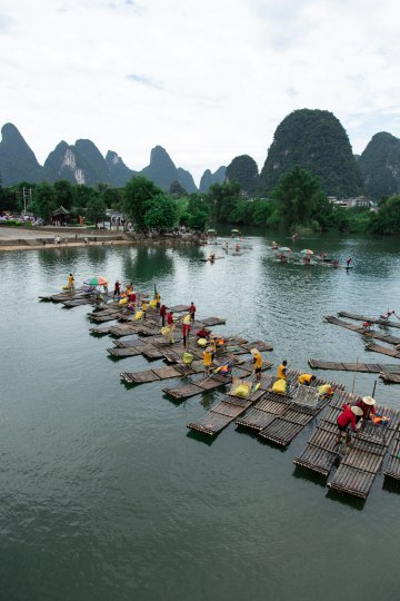 a group of people standing on wooden rafts in a body of water Via Unsplash (by Sam Balye)