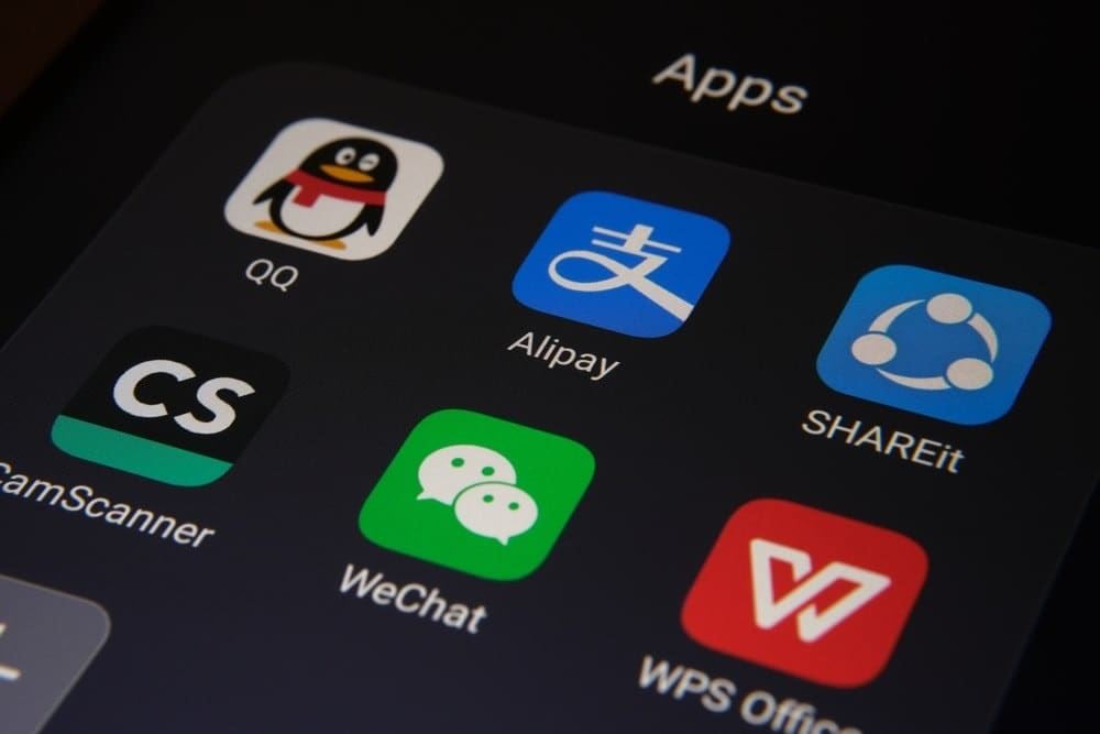 Экран смартфона с китайскими приложениями Alipay, WeChat, QQ и WPS Office крупным планом