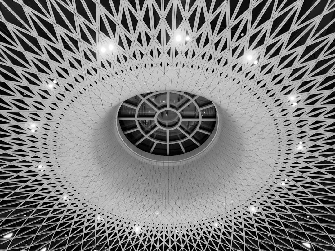 a black and white photo of a ceiling Via Unsplash (by Wei Shen)