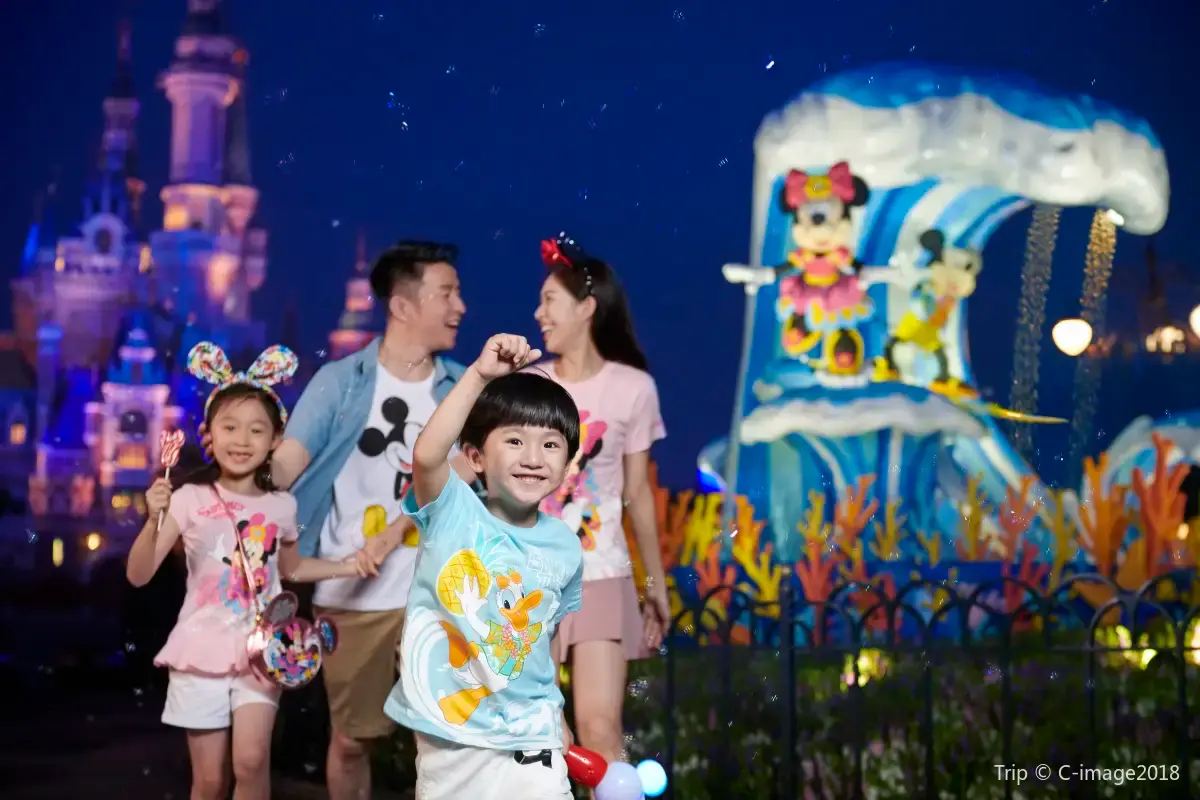 上海ディズニーランドでパレードを楽しむ家族。