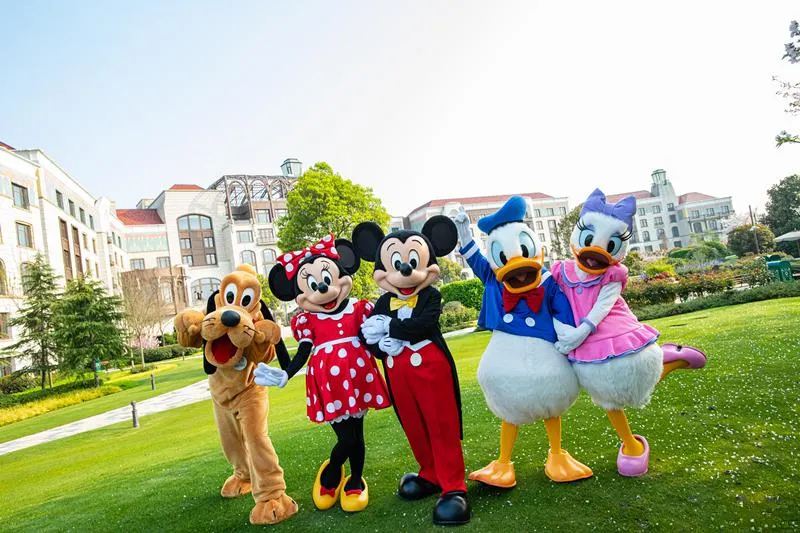 上海ディズニーランド・ホテルの前でミッキーと仲間たちが笑顔でポーズをとる。