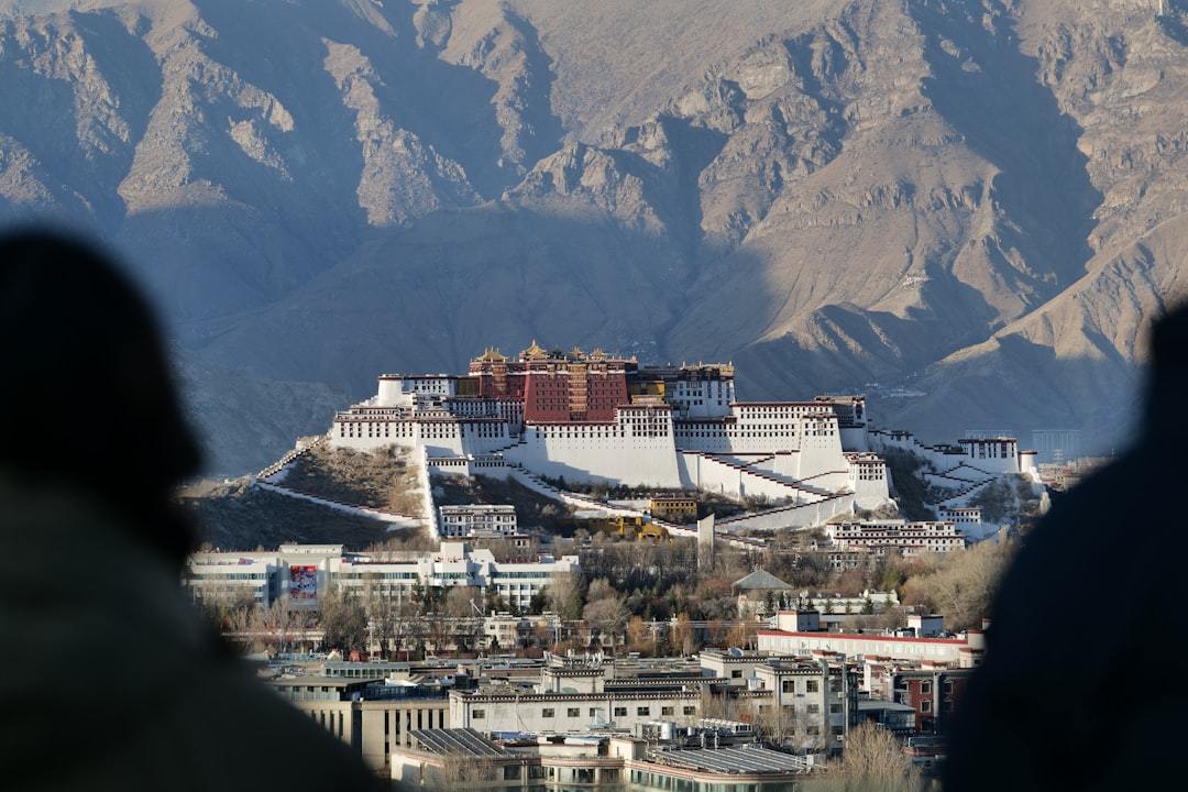 The potala palace stands majestically in the distance. Via Unsplash (by Ereng hu)
