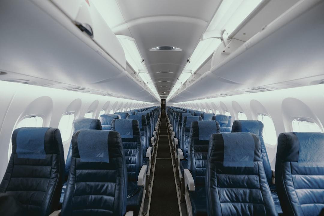 blue airplane interior with seats Via Unsplash (by JC Gellidon)