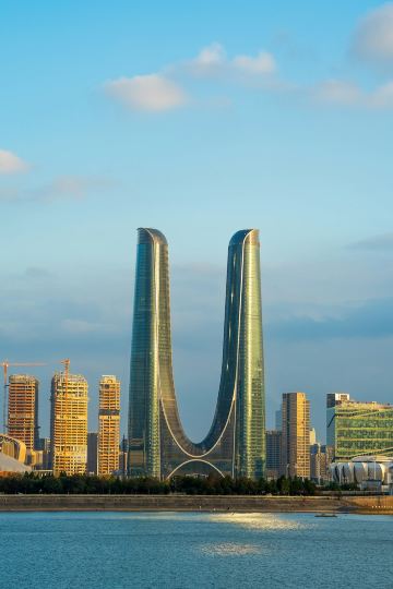 A large body of water with a city in the background Via Unsplash (by JinHui CHEN)
