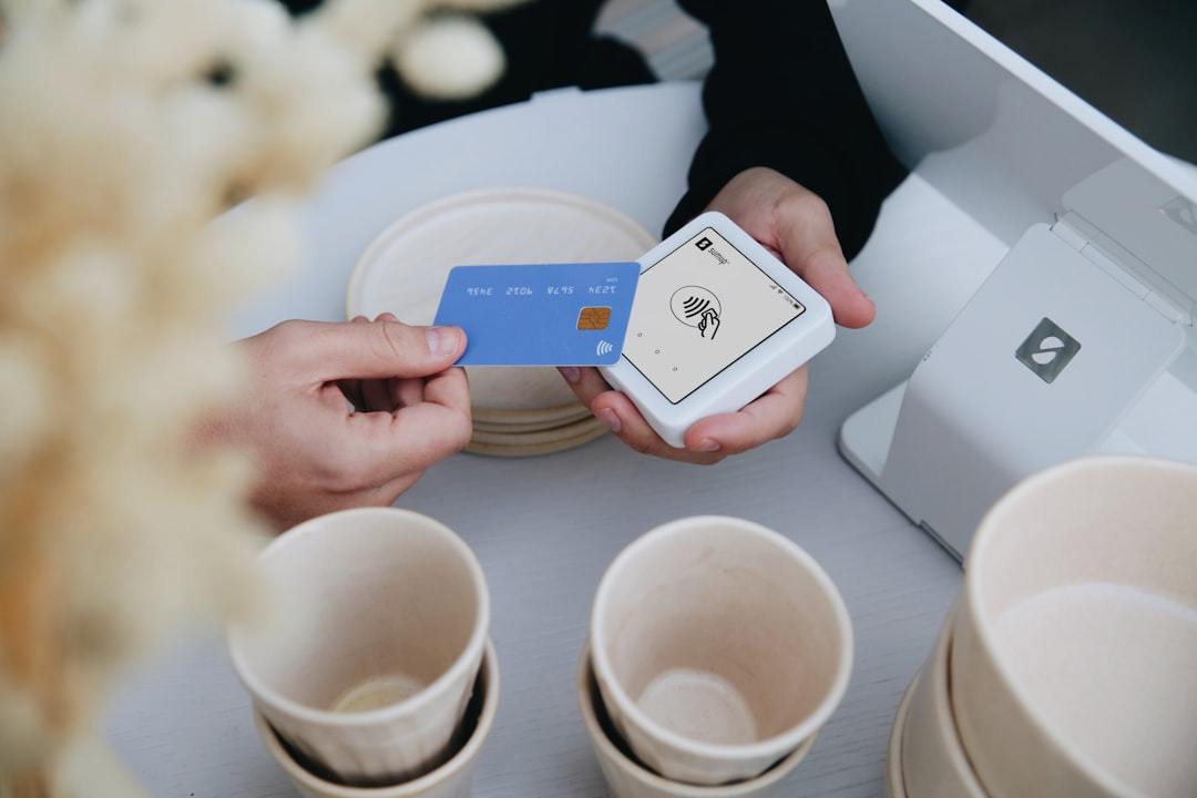 Paying with a credit card at a register. Via Unsplash (by SumUp)