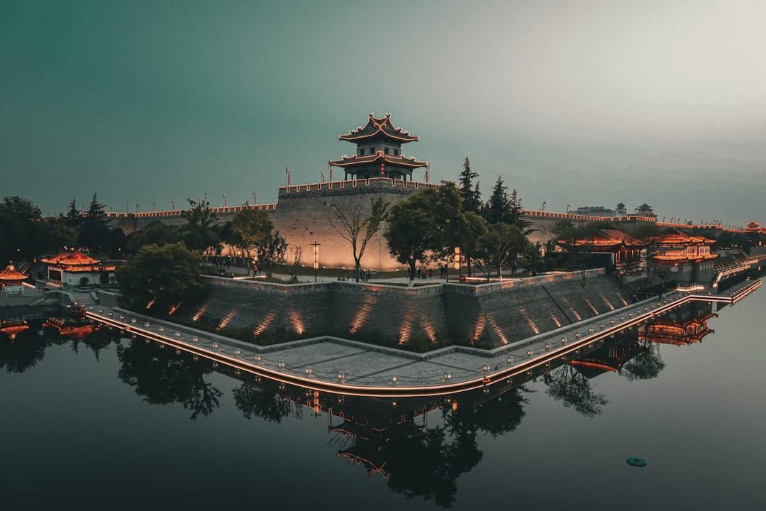 A large building sitting on top of a body of water Via Unsplash (by 政 闫)