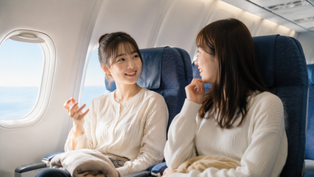 飛行機で話す友達