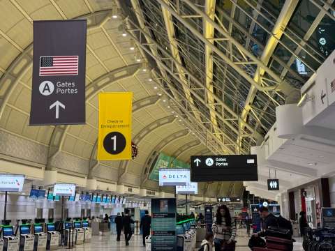   「カナダ最大の空港って広すぎて、次の便に間に合うかハラハラする……」 「アメリカへの乗り継ぎ、入国審査の手順がややこしくて不安だな」 海外旅行の大きな山場といえば、やはり乗り継ぎですよね。 特にトロント・ピアソン国際空港はカナダを代表する巨大なハブ。 初めて利用する方や、限られた時間で移動しなければならない方にとって、 あの広大なターミナルはまるで迷路のように感じてしまうかもしれません。 結論から言うと、トロントでの乗り継ぎは「事前準備」と「ターミナルの把握」さえできていれば、驚くほどスムーズに完了します！ その理由は、空港内の案内表示が非常に分かりやすいこと、 そしてアメリカへ向かう場合は空港内で事前に審査を済ませられる「事前検疫（Preclearance）」という便利なシステムがあるからです。 この記事では、スムーズな手順から待ち時間の楽しみ方まで分かりやすく解説します。 読み終わる頃には、乗り継ぎへの不安がワクワクに変わっているはずですよ！ トロント・ピアソン空港行きの人気航空券を探す 羽田空港→トロント・ピアソン空港行きの航空券 伊丹空港→トロント・ピアソン空港行きの航空券   トロント・ピアソン空港の乗り継ぎは「アメリカ行きかどうか」で全てが変わる  トロント・ピアソン国際空港から目的地がアメリカの場合は、 空港内で米国入国前審査（USプレクリアランス）を受ける必要があります。 この米国入国前審査は、カナダにいながらアメリカ合衆国の入国審査官による面接や税関申告を行うもので、 通過には通常の保安検査よりも長い時間を要します。 同じ「国際線から国際線への乗り継ぎ」でも、アメリカ行きとそれ以外の国行きでは、 通過するゲートも必要な待機時間も全くの別物と考えなければなりません。 国際線の乗り継ぎだから余裕だろうという感覚でスケジュールを組むと、 審査の長蛇の列を前にして、搭乗時間に間に合わないという最悪の失敗を招くリスクも。 特に午後の出発ピーク時間帯（14時から17時頃）は、 アメリカ便が重なるため、審査場が非常に混雑しやすく、予定が狂いやすいことを念頭に置きましょう。   トロント・ピアソン空港の乗り継ぎ手順を行き先別に整理   トロント・ピアソン空港での乗り継ぎルートと主な手続きを以下の表にまとめました。 自身の旅程がどのパターンに該当するか、まずは全体像を把握することから始めてください。 乗り継ぎパターン 主な手続き内容 保安検査の有無 カナダ国内線へ カナダ入国審査・税関 あり 国際線（米以外）へ トランジット専用通路移動 ケースによりあり アメリカ行きへ 米国入国前審査（CBP） あり 国際線 → カナダ国内線へ乗り継ぐ場合 国際線からカナダ国内線（バンクーバーやモントリオール行きなど）へ乗り継ぐ際は、 トロントがカナダ最初の到着地となるため、必ず入国審査と税関検査を受ける必要があります。 まずは「Arrivals」の案内に従い、キオスク端末で税関申告を行い、 審査官のブースを通過してカナダへの入国手続きを完了させてください。 多くの場合、一度預け荷物をバゲージクレームでピックアップし、 税関を通過した直後にある「Connections」用のベルトに荷物を再度預け入れる流れとなります。 その後、国内線ゲートへ向かうための保安検査を受ける必要があるため、 液体物の持ち込み制限などには再び細心の注意を払わなければなりません。 トロント・ピアソン空港のターミナル1とターミナル3の間を移動する場合は、 数分間隔で運行されている無料列車「ターミナル・リンク・トレイン」を利用しましょう。 国内線チェックインは自動機で行えることが多いですが、 混雑時には保安検査場を通過するだけで40分以上を要することもあるため、早めの行動が不可欠です。 国際線 → 国際線へ乗り継ぐ場合（アメリカ以外） 国際線からアメリカ以外の第3国（中南米やヨーロッパなど）へ向かう場合は、 条件次第でカナダに入国することなく「International Connections」の通路を利用して乗り継げます。 このルートを利用できれば入国審査をスキップできるため、他のパターンと比較すると身体的な負担は少ないですが、 航空会社や到着ターミナルによっては再保安検査が発生します。 特に日本からの直行便が到着するターミナル1から、他社便が発着するターミナル3へ移動する際は、 移動時間も含めて予想以上に体力を消耗するものです。 また、国際線の出発ゲートは直前に変更されることが頻繁にあるため、 通路に設置されたフライトモニターで最新の「Gate Number」をこまめに確認してください。 もし乗り継ぎ時間が5時間以上ある場合、カナダに入国してトロント市内へ出ることも可能ですが、 再入国時の混雑を考慮するとあまり現実的な選択肢ではありません。 空港内では無料Wi-Fiが利用できるため、 次のフライトの状況やTrip.comのアプリで搭乗時刻の最終チェックをして過ごすのが賢明です。 国際線 → アメリカ行きへ乗り継ぐ場合 国際線からアメリカ行きへ乗り継ぐパターンは、 トロント・ピアソン空港において「最大の難所」と言われていて、非常に特殊な手順を踏むことになります。 このルートの最大の特徴は、 カナダに居ながらにしてアメリカ合衆国の入国審査（CBP）と税関検査を完了させるプレクリアランスを通過しなければならない点です。 審査官による面接や指紋採取、顔認証が行われるため、 混雑時には審査待ちの列だけで1時間を超えることも珍しくなく、通常の国際線乗り継ぎとは次元が異なります。 審査を通過した後の待合エリアは「米国内」という扱いになるため、 一度入るとカナダ側の免税店やラウンジに戻ることは一切できないことを覚えておきましょう。 検査後はアメリカ国内線と同様の扱いで搭乗でき、目的地（ニューヨークやシカゴなど）に到着した後は、 入国審査を受けずにそのまま出口へ向かえるのがメリットです。 このプレクリアランスの手続きは、午前10時から午後3時までの時間帯が最も混み合い、 乗り継ぎ時間が3時間未満だと乗り遅れのリスクが非常に高まります。 トロント・ピアソン空港行きの人気航空券を探す 成田国際空港→トロント・ピアソン空港行きの航空券 関西国際空港→トロント・ピアソン空港行きの航空券   トロント・ピアソン空港の乗り継ぎ時間はどれくらい必要？  トロント・ピアソン国際空港 乗り継ぎに必要な時間は、利用する航空会社や時間帯、そして最終目的地によって以下のように変動します。 目安となる最低時間と、推奨される安心時間をまとめました。 乗り継ぎパターン 最低必要な時間 推奨される安心時間 国際線 → カナダ国内線 2.5時間 3時間以上 国際線（米以外）へ 2時間 3時間以上 アメリカ行きへ 3.5時間 4時間以上 国際線 → カナダ国内線は【最低2.5時間／安心は3時間】 国際線からカナダ国内線へ乗り継ぐ場合、入国審査と荷物の再預け入れが必要となるため、 最低でも2.5時間は確保しておくべきです。 トロント・ピアソン空港の入国審査場は、夕方の国際線到着ラッシュ時（15時〜18時頃）には非常に混雑し、 審査官のブースに辿り着くまでに1時間近くかかることもあります。 もし預け荷物のピックアップが遅れたり、税関で追加の質問を受けたりすれば、 2.5時間という時間はあっという間に過ぎ去ってしまうでしょう。 万が一、到着便が30分遅延しただけで乗り継ぎが不可能になるリスクを避けるためにも、 スケジュールには3時間程度の余裕を持たせておくと、精神的にも楽になります。 Trip.comなどの予約サイトで便を選ぶ際は、乗り継ぎ時間が短すぎる組み合わせを避け、 少し遅い時間の国内線を選択することをおすすめします。  国際線 → 国際線（アメリカ以外）は【最低2時間／余裕なら3時間】 アメリカ以外への国際線乗り継ぎは入国審査が不要なケースが多いですが、 空港の広さを考慮すると3時間あるのが最も理想的です。 トロント・ピアソン空港は非常に巨大な建築物で、 ゲートからゲートへの移動だけで徒歩20分以上かかるエリアも存在することを忘れてはいけません。 特にエア・カナダ（ターミナル1）から他社便（ターミナル3）へ移動する場合、 ターミナル間移動の列車待ち時間も含めると、予想以上に時間が削られてしまいます。 また、国際線の搭乗ゲートは出発の20分〜30分前には閉まってしまうことが多いため、 実質的な自由時間は表示されている乗り継ぎ時間よりも短いのが現実です。 免税店でメープルシロップなどを購入する時間も含めて考えると、 3時間程度の余裕を持っておくのが、精神衛生上も最も良い選択と言えるでしょう。 国際線 → アメリカ行きは【最低3.5時間／理想4時間以上】 アメリカ行きのフライトへの乗り継ぎがある場合は、 他のどのパターンよりも長い、最低3.5時間から理想的には4時間以上の時間を確保してください。 米国入国前審査（CBP）の列は、予測が非常に難しく、空いている時は15分で終わりますが、 混雑時には2時間近くを要することもあるからです。 さらに、アメリカ便専用の保安検査場も非常に厳格で、靴を脱ぐ、電子機器をすべて出すといった作業により、 通過に時間がかかる傾向が顕著に見られます。 ストレスを避け、ゲート前のカフェで落ち着いて過ごすためには、 最初から4時間以上の乗り継ぎ便を航空券予約時に選んでおくのが最善です。 特にアメリカ行きのフライトは搭乗前の最終セキュリティチェックも厳しいため、 他の国際線と同じ感覚で予定を組むと、ほぼ間違いなく失敗します。   トロント・ピアソン空港の乗り継ぎで失敗しやすい3つのポイント  多くの旅行者がトロント・ピアソン空港で乗り継ぎに失敗する背景には、 共通するいくつかの落とし穴が存在します。 これらを事前に把握することで、リスクを回避できます。 「アメリカ行き」を甘く見て時間が足りなくなる トロント・ピアソン空港での乗り継ぎ失敗で最も多い原因は、 アメリカ行きの米国入国前審査（CBP）にかかる時間を通常の国際線乗り継ぎと同じだと錯覚することです。 「同じターミナルの移動だから1時間半もあれば大丈夫だろう」という安易な考えは、 この巨大なハブ空港では通用しない非常に危険な選択となります。 入国審査官のブースに並ぶ前に、米国の税関申告書に不備がないかチェックされたり、 手荷物の追加検査が行われたりすることで、予想外に時間を消費します。 一度審査エリアに入ってしまうと、外にあるレストランや売店に戻ることもできず、 ひたすら時計を見ながら焦ることになるため、精神を大きく消耗します。 アメリカ行きの便が夕方にある場合は、特に午前中の早い便でトロントに到着するような、たっぷりとした時間設定を強く推奨します。 冬季の遅延で乗り継ぎ計画が崩れる トロントは12月から3月にかけて激しい雪や寒波に見舞われることが多く、 これによるフライトの遅延や欠航が日常茶飯事のように発生します。 ひとたび大雪が降れば、滑走路の除雪作業や機体の防氷作業のために、 出発が1〜2時間遅れることは全く珍しくありません。 最初の便が1時間遅れるだけで、本来予定していた乗り継ぎ便が物理的に不可能になってしまうリスクが常につきまといます。 冬の時期にトロントを経由する場合は、当日中に目的地に着けなくなる可能性を考慮し、 代替便の選択肢が多い午前中の便を選ぶといった工夫が必要です。 ターミナル移動の時間を想定していない トロント・ピアソン空港はターミナル1とターミナル3の2つの巨大な建物に分かれていて、 これらを繋ぐ移動には想像以上の時間を要します。 自分が利用する航空会社がどちらのターミナルに到着し、どちらから出発するかを確認せず、 空港に着いてから案内板を見て焦るのは初心者が陥りがちなミスです。 ターミナル間を結ぶ「ターミナル・リンク・トレイン」は無料で24時間運行していますが、 ホームへの移動や待ち時間を合わせると、最低でも20分はロスすると見積もるべきです。 特に大きな手荷物を持っていたり、小さなお子様連れで移動したりする場合は、 さらに時間がかかることを覚悟して行動を開始しなければなりません。 到着ゲートからターミナル移動、そして次の保安検査場までという一連のプロセスを一つの大きな山場と捉え、 時間に余裕を持って行動することが大切です。 航空券予約時に気をつけたいトロント・ピアソン空港乗り継ぎのコツ