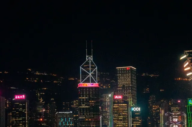 Hong Kong's Central skyline lit up at night, seen across Victoria Harbour