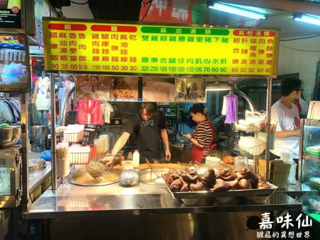 嘉味仙麻油雞腿庫飯的攤位外觀，招牌與價目表掛在店門口