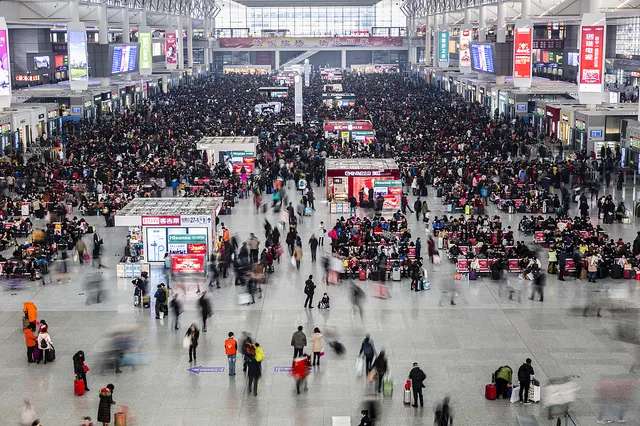 Crowded railway station with passengers and trains