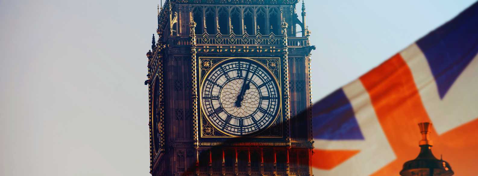 Reloj del Big Ben en Londres con la bandera del Reino Unido en primer plano