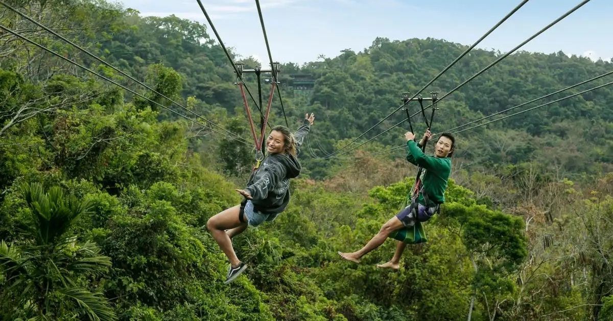 Visitantes recorriendo una tirolina sobre la vegetación de la Selva Tropical de Yanoda, en Hainan.