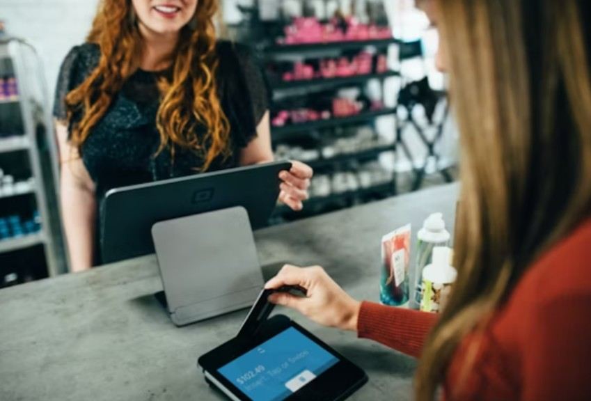 A woman paying for something in a shop
