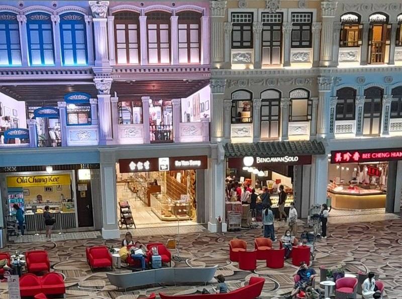 Colorful shophouse facades and food outlets inside an airport terminal