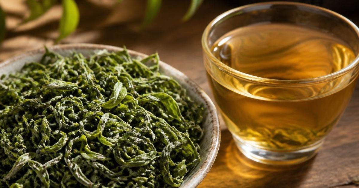 Hojas enrolladas y taza de té verde Biluochun de Suzhou.
