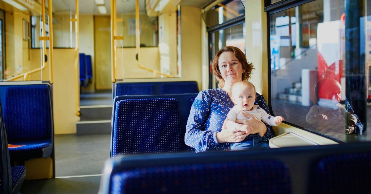 Woman sitting with her baby on the lap inside a modern train carriage