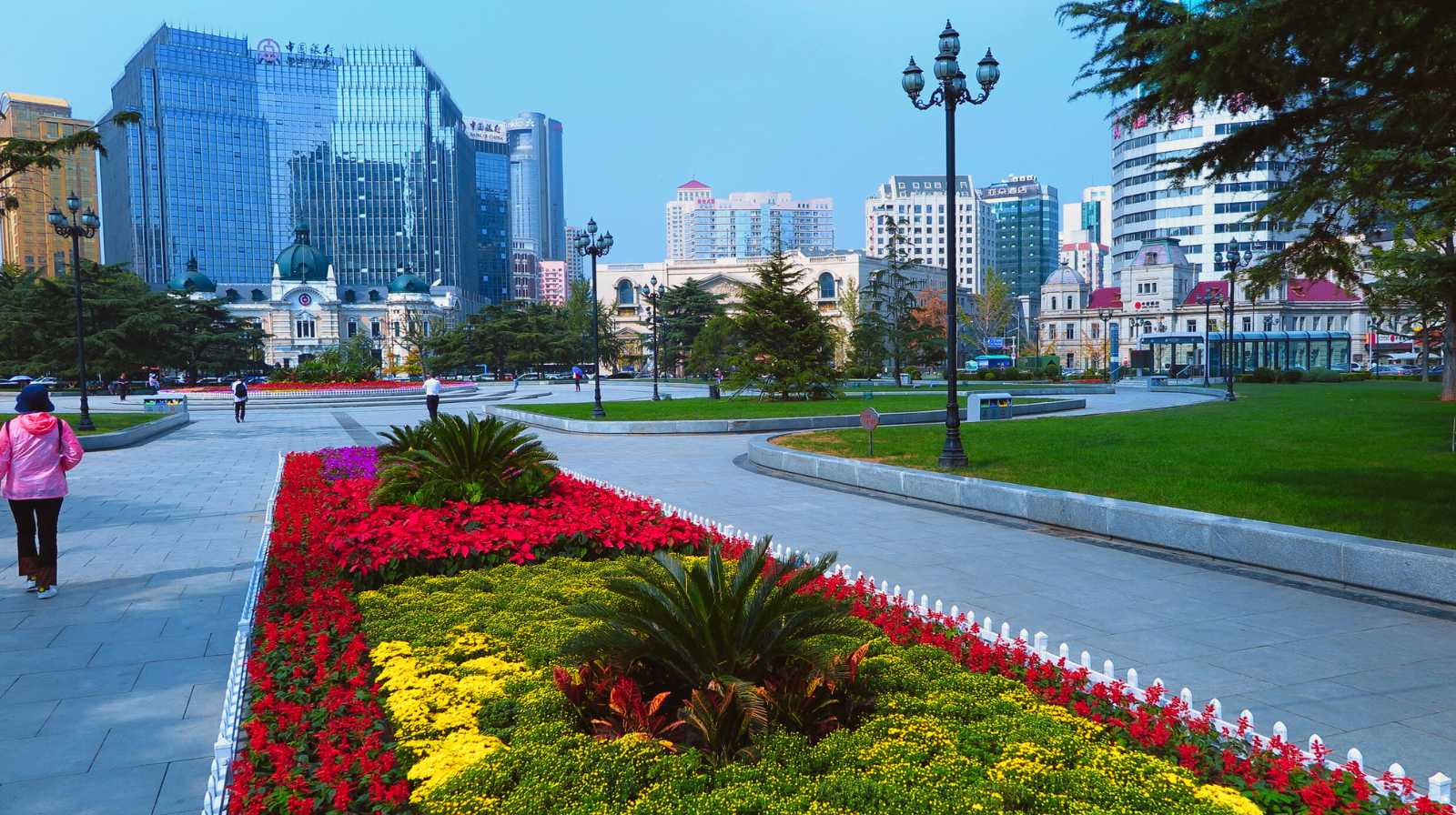 Jardines florales en un parque de Taipéi con rascacielos modernos al fondo