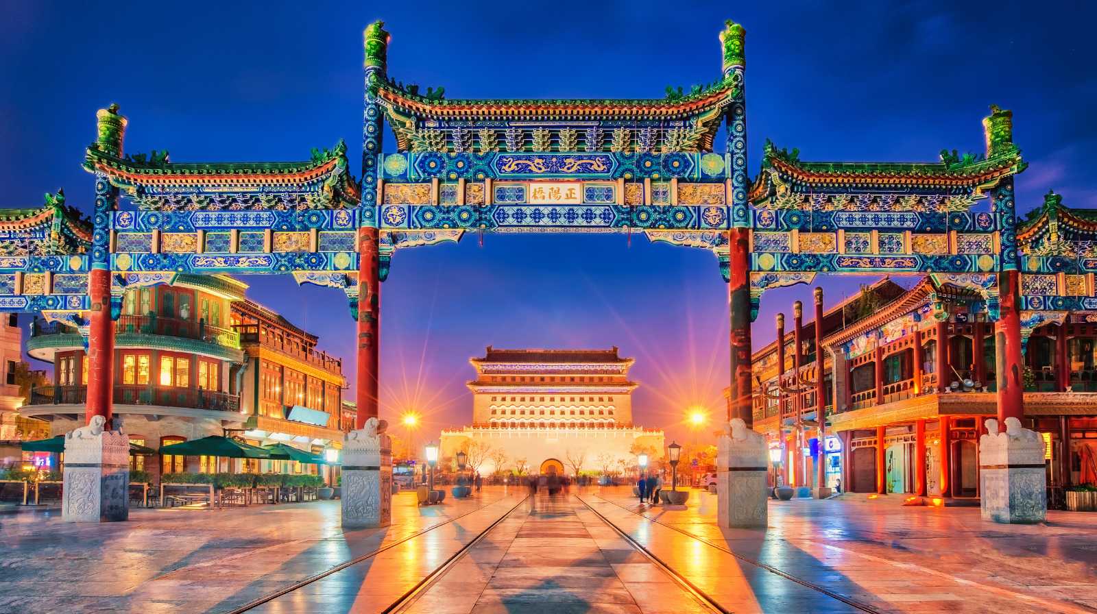 Arco tradicional chino iluminado al anochecer en una zona histórica y comercial