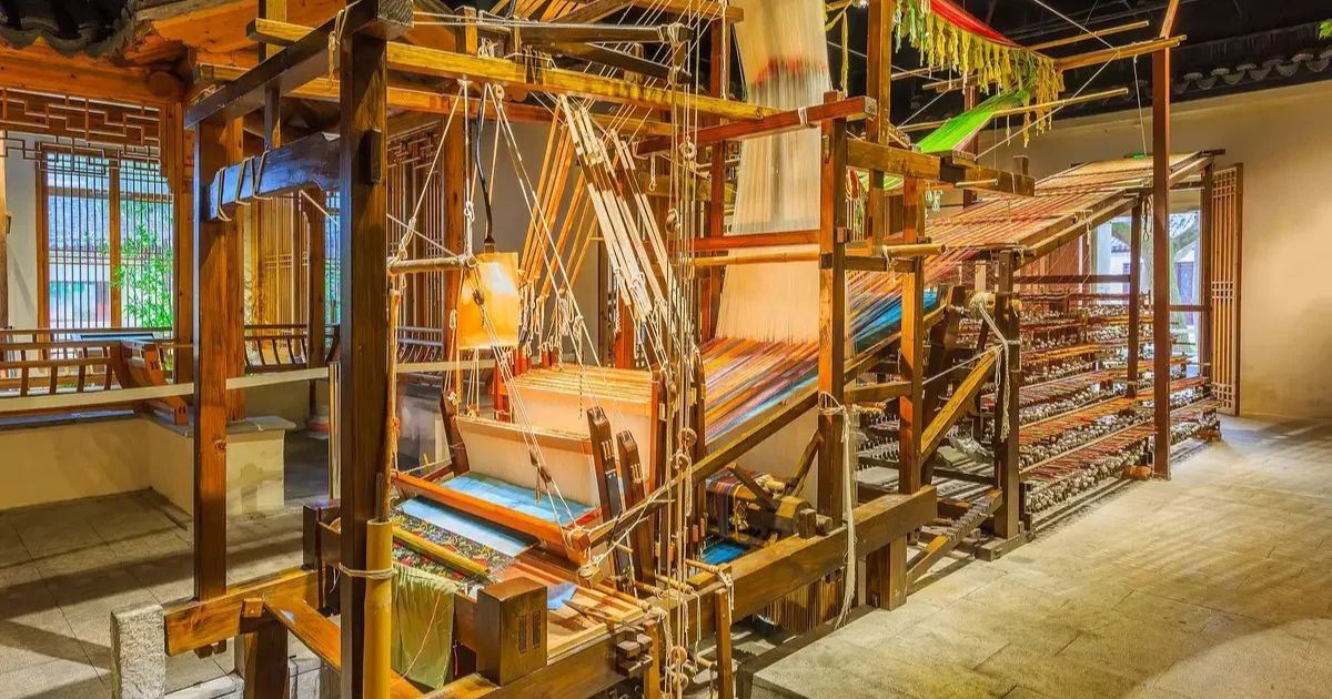 Telares tradicionales de madera con hilos de colores expuestos en el Museo de la Seda de Suzhou.