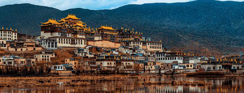 Monastero tibetano a Shangri-La, con la sua architettura tradizionale e le montagne sullo sfondo, nella provincia dello Yunnan.