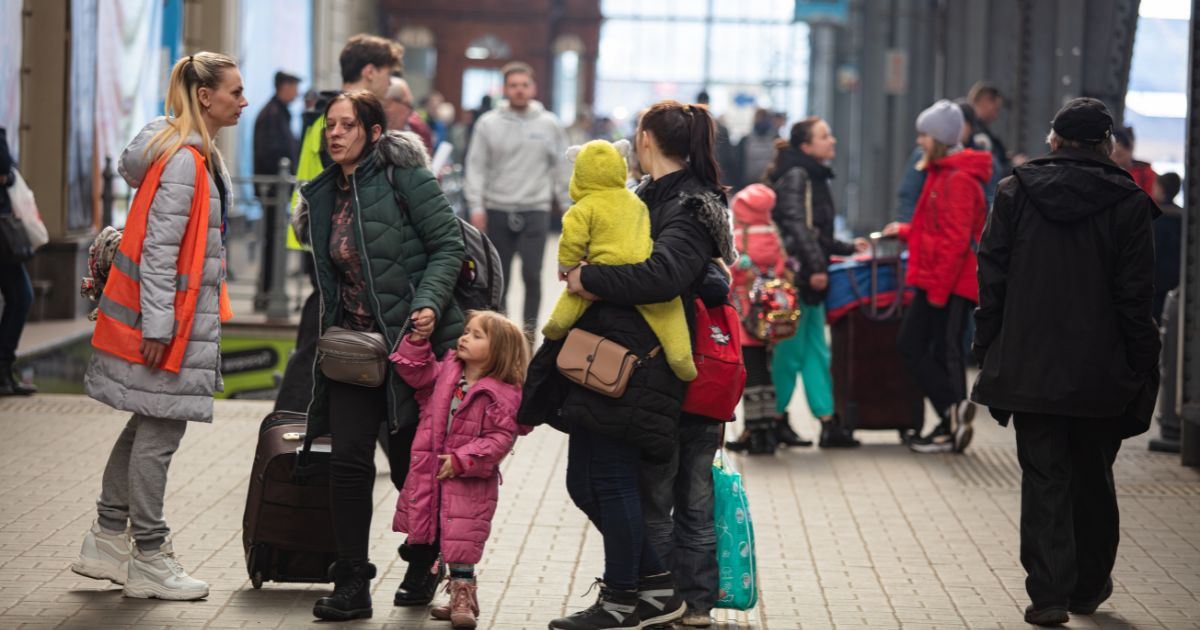 A family with small children carrying luggage at railway station