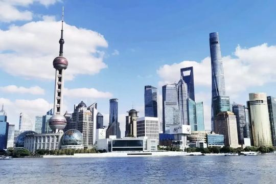 Shanghai skyline featuring the Oriental Pearl Tower and Lujiazui skyscrapers across the Huangpu River
