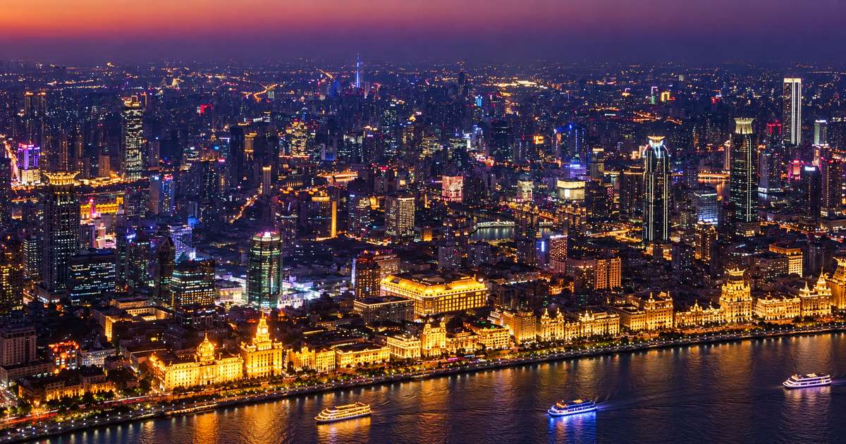 Prédios de Xangai iluminados e fachadas do Bund vistos do alto ao anoitecer