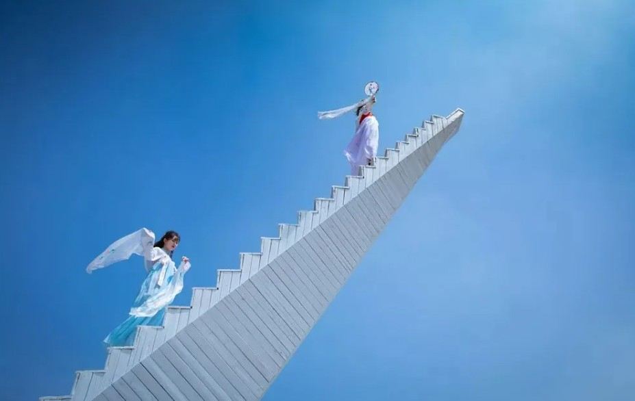 White staircase rising above the mountains under a clear blue sky