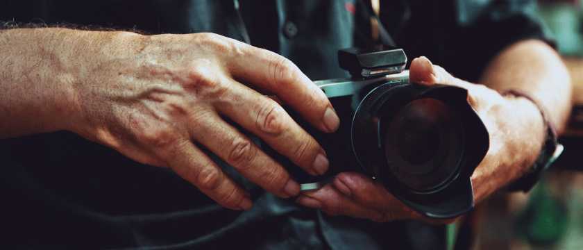 Fotógrafo sosteniendo cámara profesional listo para tomar fotos durante un viaje.