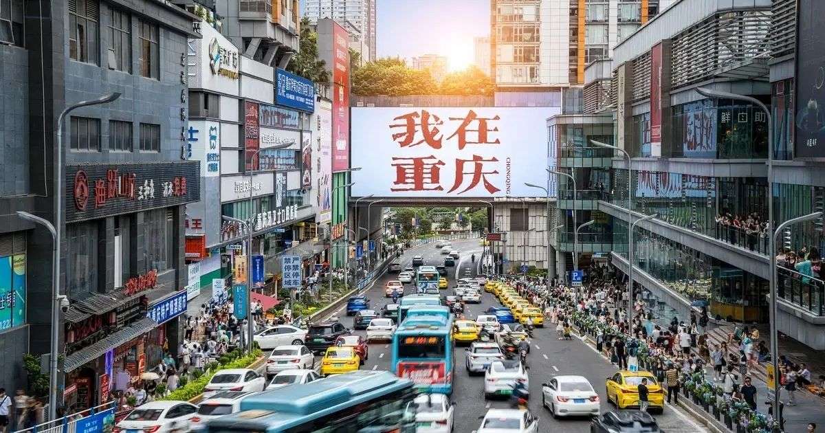Zona comercial de Guanyinqiao en Chongqing, con tráfico, grandes edificios, comercios y ambiente urbano.