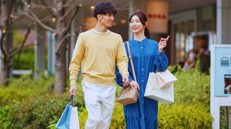 Una coppia passeggia con i sacchetti dello shopping in una zona commerciale di Pechino.