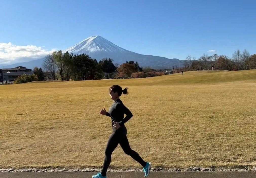 Traveler jogging across empty lanes with clear Mount Fuji view