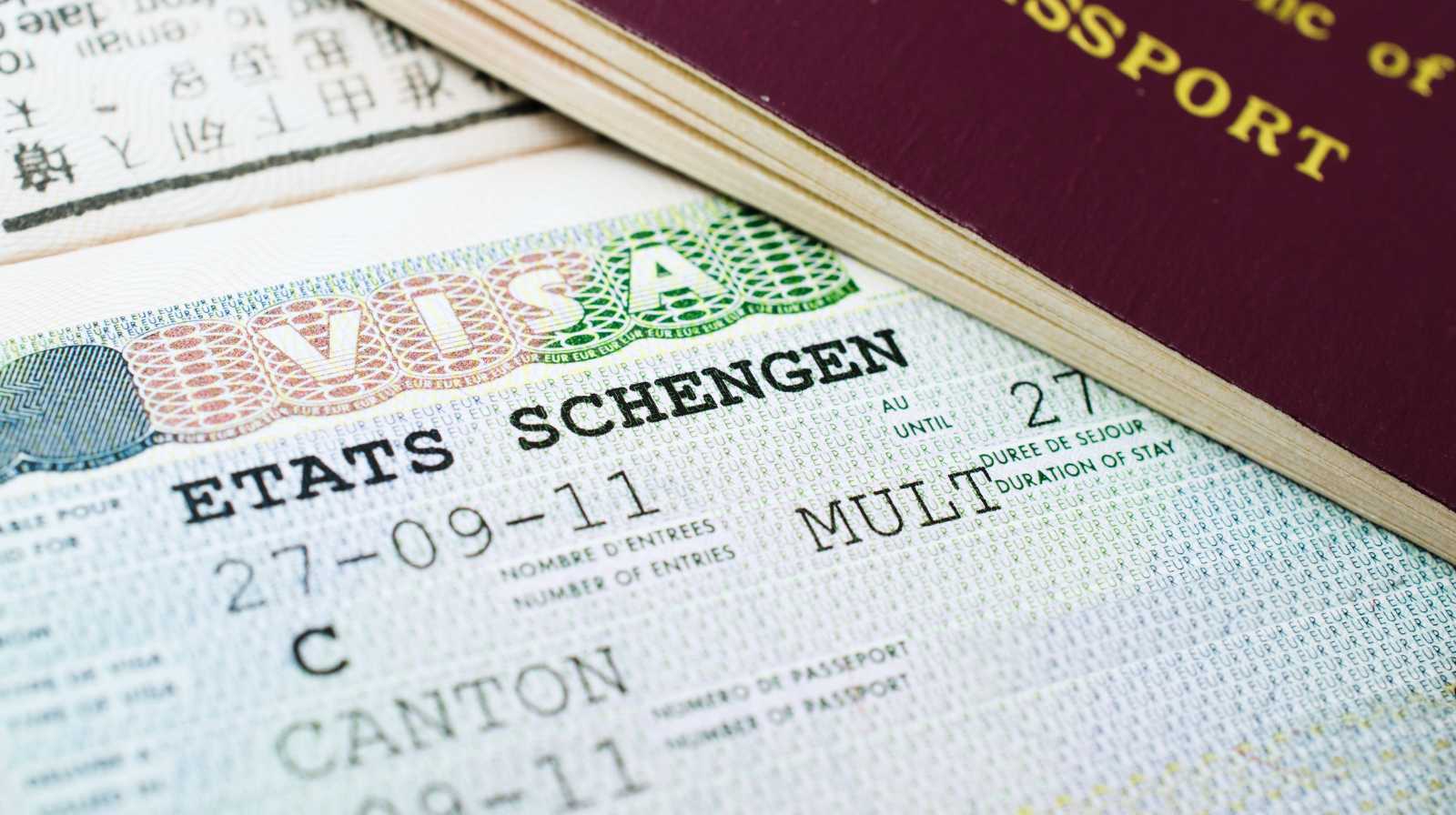 Primer plano de un visado Schengen junto a un pasaporte europeo