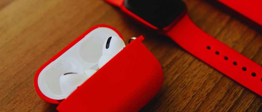 Auricolari wireless in una custodia rossa appoggiati su un tavolo di legno