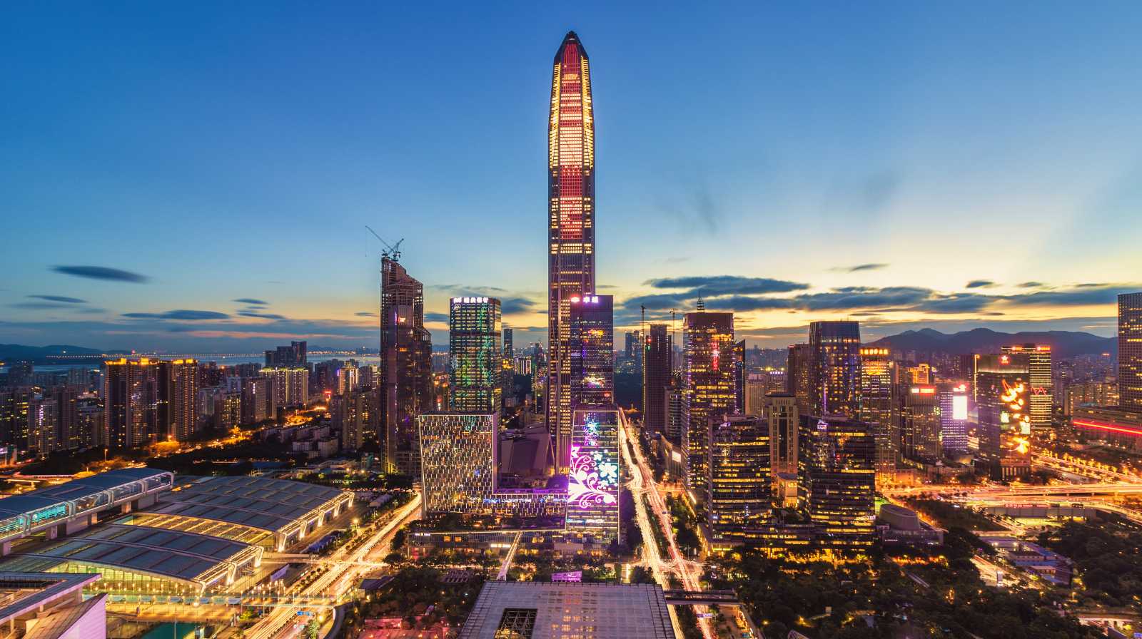 Panorámica urbana de un distrito financiero chino al atardecer con rascacielos iluminados