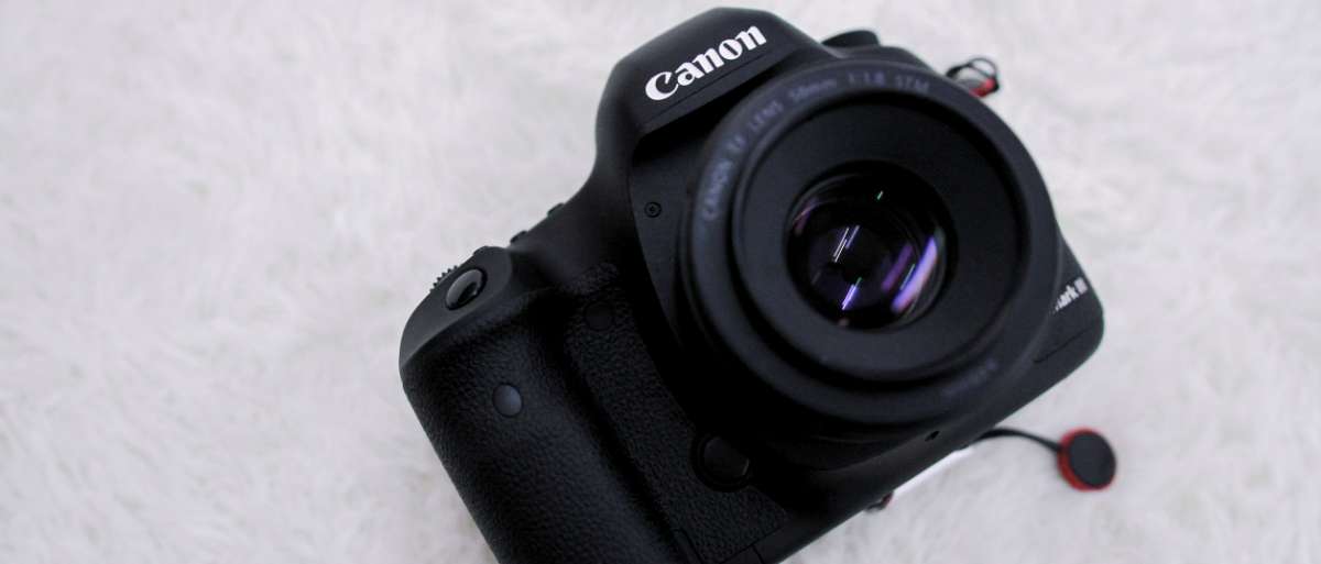 Appareil photo reflex Canon avec objectif 50 mm au premier plan