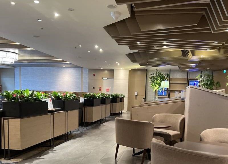 Modern airport lounge with private seating areas and indoor plants