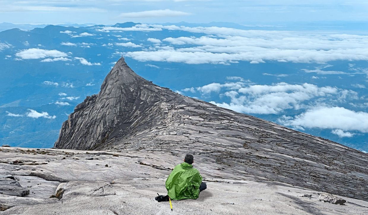 A weary traveller at the peak of mount kinabalu