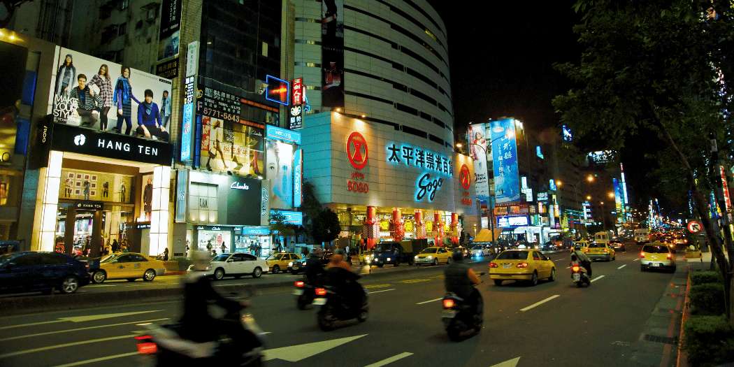 La rue commerçante de Ximending, qui brille de mille feux à la nuit tombée, animée par la circulation et ses néons éclatants.