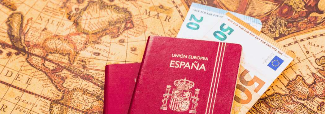 Pasaportes españoles y euros sobre mapa antiguo durante la planificación de un viaje internacional a Turquía