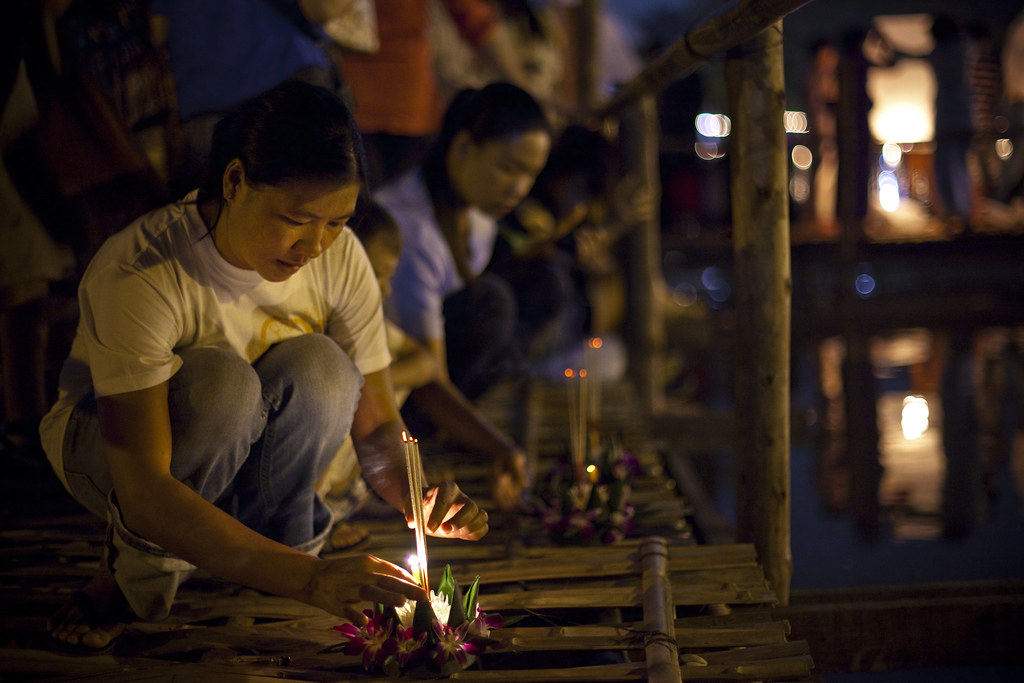 Locals lighting up candles on Lotus flowers and sending them down the river as prayers and respect