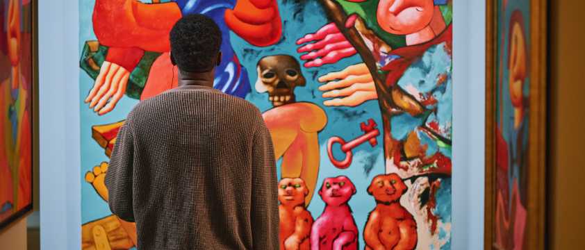 A visitor admiring a contemporary painting with vibrant colours in a Shanghai art gallery